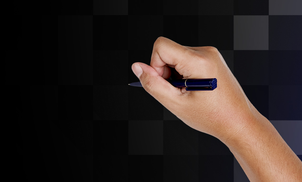 Et billede af en hånd, der skriver med en kuglepen